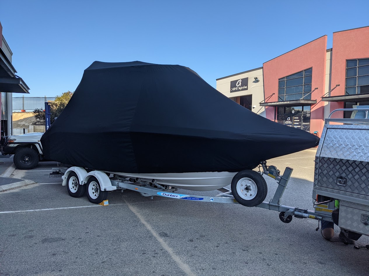 Large custom full boat cover in black Sattler marine acrylic, fitted over a boat on its trailer